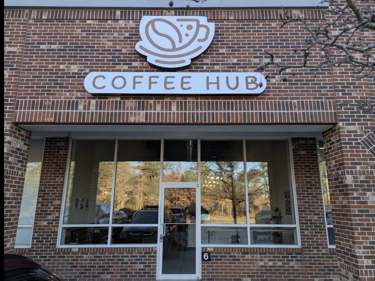 Coffee Hub storefront with its coffee cup sign above the entrance